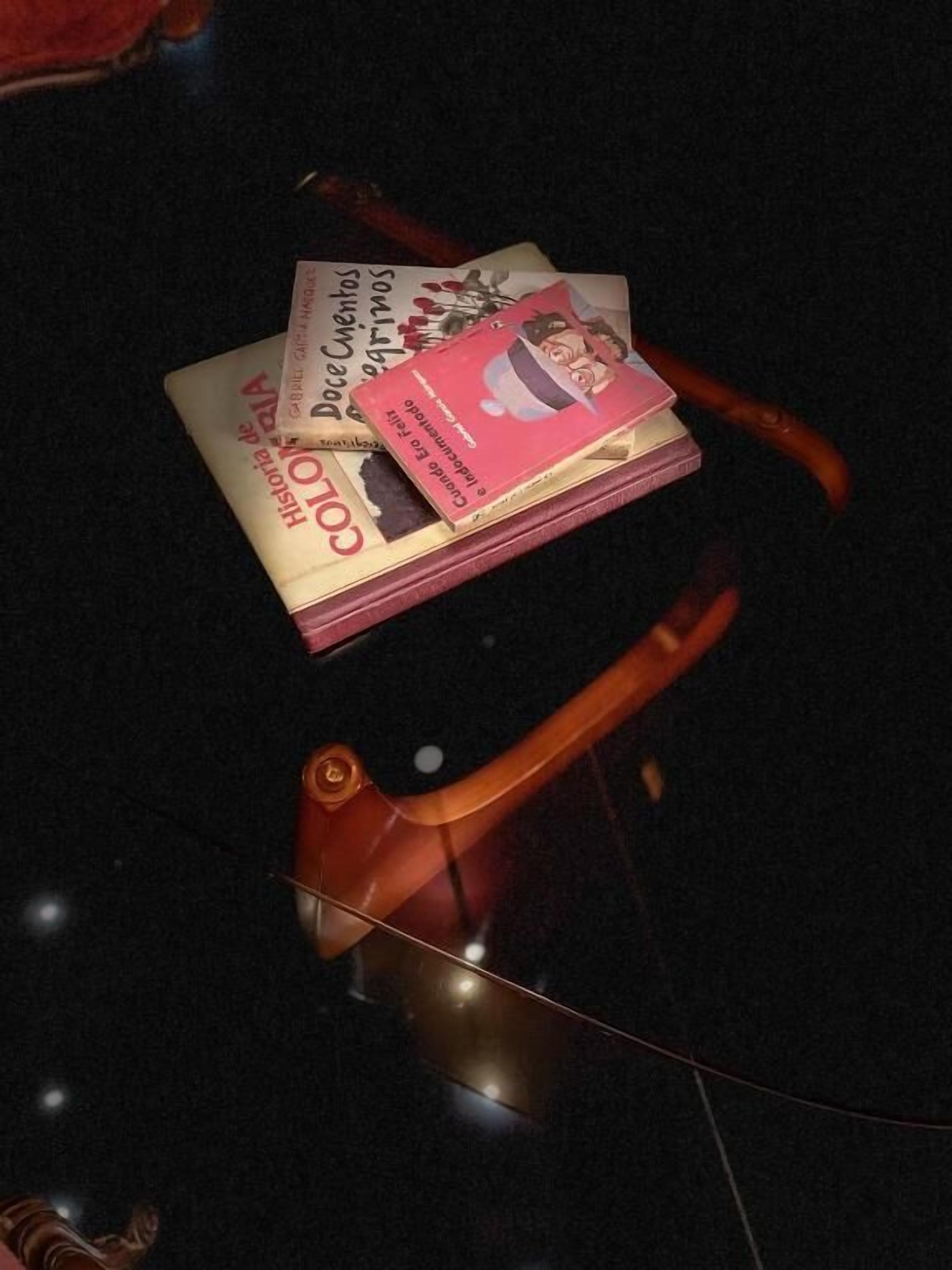 Una pila de libros sobre una mesa con una silla.
