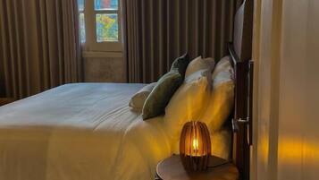 Une chambre à coucher avec un lit, une lampe de chevet et une fenêtre avec des rideaux.