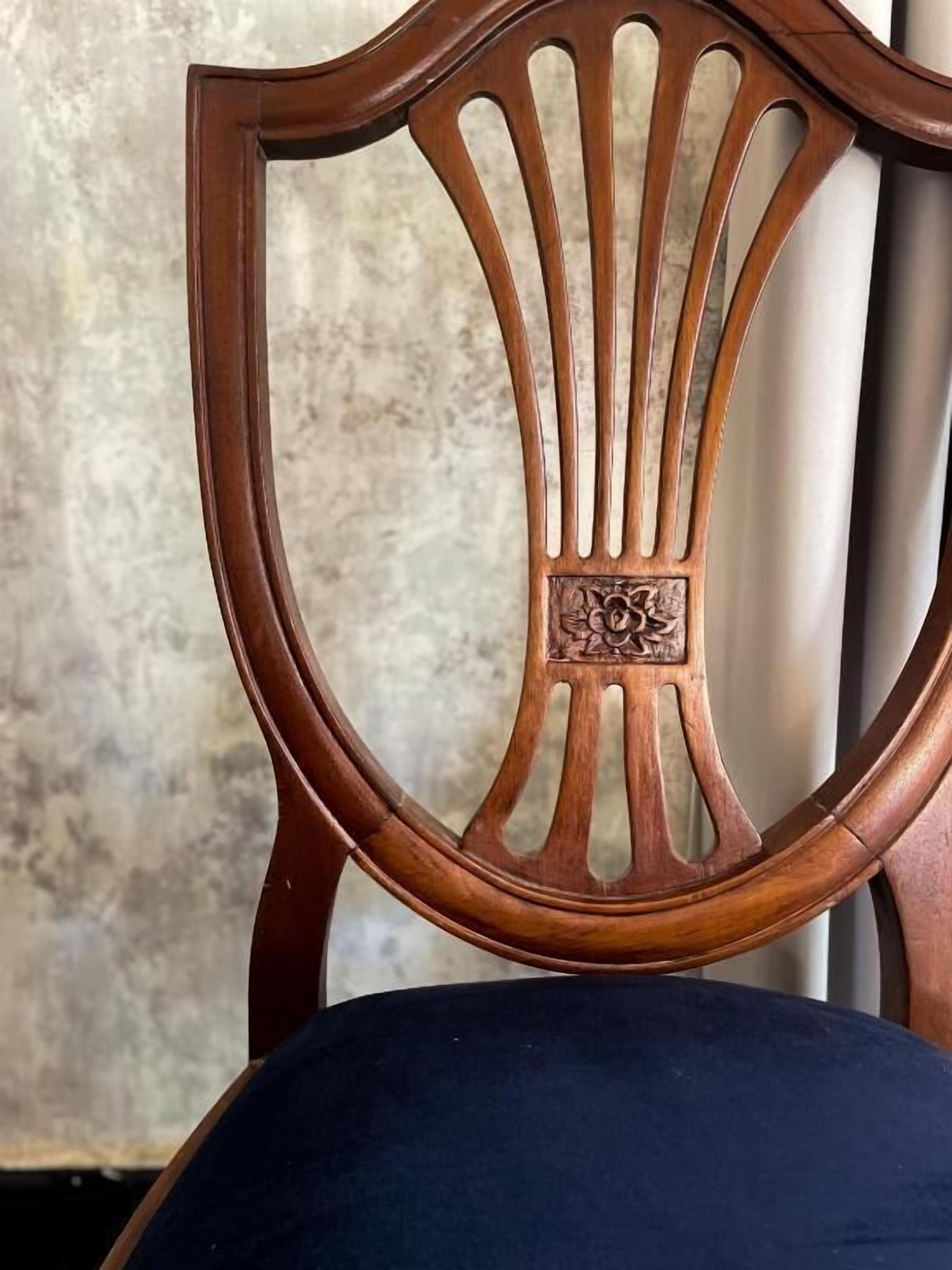 A wooden chair with a backrest featuring a central decorative panel and vertical slits.