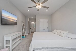 A bedroom with a bed, a ceiling fan, a TV on the wall, a wardrobe, and a ladder. - Brand NEW Calabash Condo (Calabash)