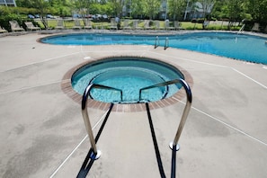 A swimming pool with a glass bottom, surrounded by a concrete deck and metal pool ladder. - Brand NEW Calabash Condo (Calabash)