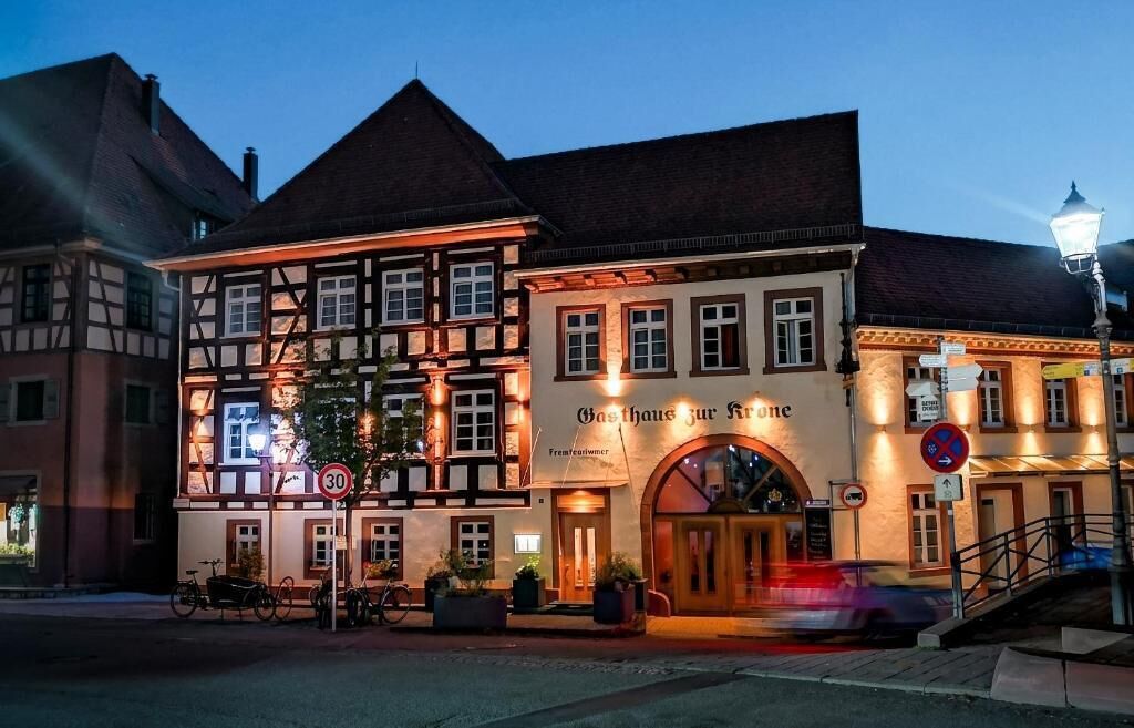 A traditional half-timbered building with a sign reading 'Gasthof zur Krone' and a speed limit sign of 30.