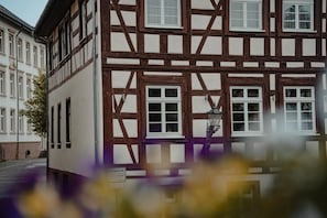 A traditional half-timbered building with multiple windows and a visible street in front.