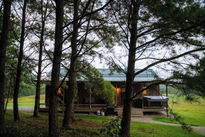 A cabin with a porch, surrounded by trees. - Private Cabin with Pond, Hot Tub and Hiking Trails (Logan)