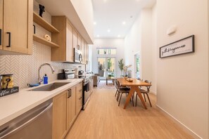 Une cuisine moderne avec des meubles en bois, un four encastré et un coin café.