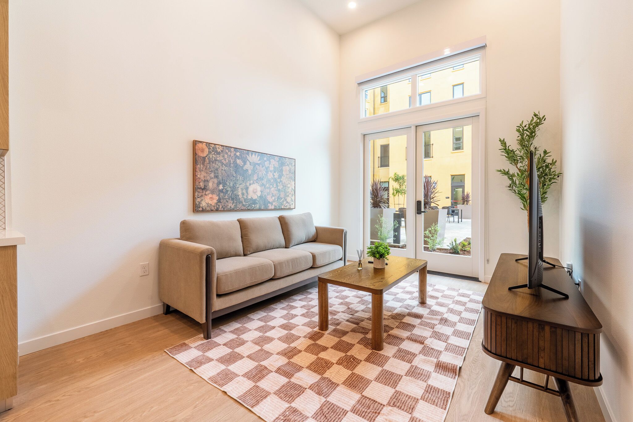 Una sala de estar moderna con un sofá, una mesa de centro y un mueble para televisión.