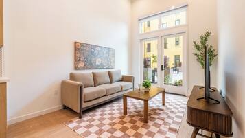 Una sala de estar moderna con un sofá, una mesa de centro y un mueble para televisión.