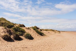 A sandy beach with dunes and sparse vegetation. - Cozy 4BR Redcar House | Sleeps 7 | Close to Beach (Redcar and Cleveland)