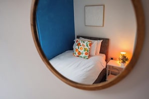 A bedroom with a bed, a nightstand, a lamp, and a framed picture on the wall. - Cozy Blue Ember Stay | Work friendly 4BR+Sleeps 7 (Redcar and Cleveland)