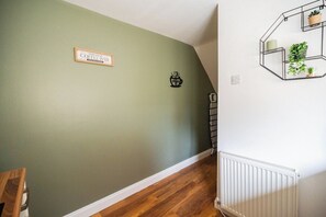 A hallway with a green wall, a coffee bar sign, and a radiator. - The Alfred 4BR Suite in Redcar | Sleeps 7+Parking (Redcar and Cleveland)