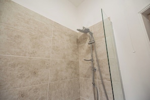 A shower with a glass door, beige tiles, and a handheld showerhead. - The Alfred 4BR Suite in Redcar | Sleeps 7+Parking (Redcar and Cleveland)