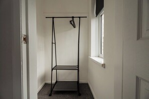 A narrow hallway with a black metal rack against the wall, a window on the right, and a door on the left. - 3BR Barnaby House | Contractor Friendly | Sleeps 5 (Redcar and Cleveland)