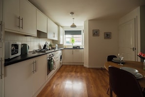 A kitchen with white cabinets, a wooden countertop, a sink, and a window with a view. - 3BR Einstein House in Hardwick | Work Friendly (Stockton-on-Tees)
