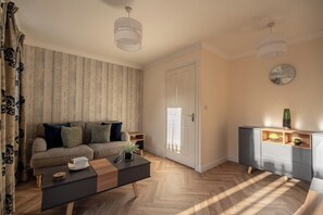 Ein modernes Wohnzimmer mit Sofa, Couchtisch und Schrank.