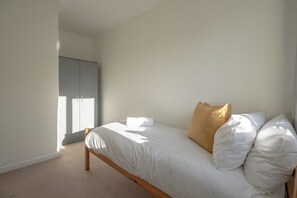 A bedroom with a single bed, a wardrobe, and a window. - Stylish 2BR Pottery Wharf Retreat | Sleeps 3 (Thornaby)