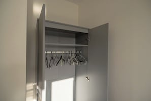 A wardrobe with multiple shelves and a hanging rod for clothes. - Stylish 2BR Pottery Wharf Retreat | Sleeps 3 (Thornaby)