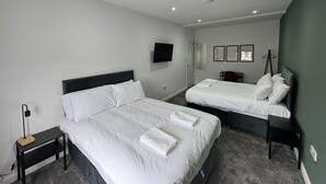 A hotel room with two beds, a TV, a desk, and a chair. - 6 Bed Contractor Acom in Hartlepool (Hartlepool)