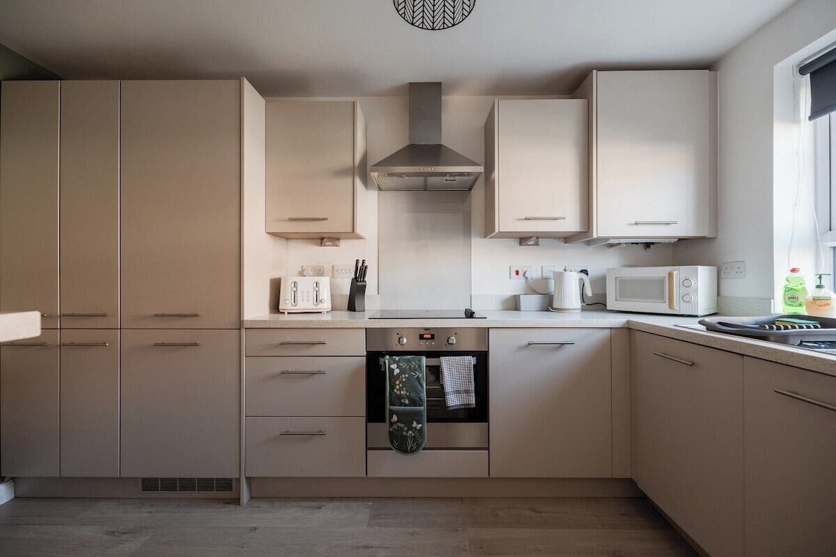 A modern kitchen with built-in appliances, including a microwave, oven, and toaster.