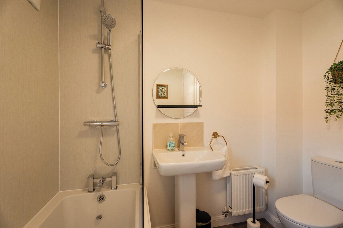 Een badkamer met een bad, een wastafel, een toilet en een spiegel.