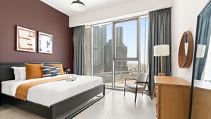 A modern hotel room with a large bed, a desk, a chair, and a view of the cityscape. - Silkhaus Luxe 3BR Apartment by the Canal (Dubai)