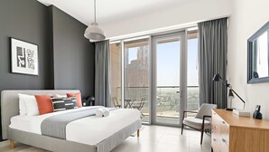 A modern hotel room with a large bed, a desk, and a balcony with a city view. - Silkhaus Luxe 3BR Apartment by the Canal (Dubai)