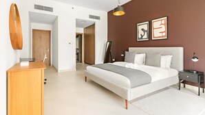 A modern bedroom with a bed, bedside tables, a desk, and artwork on the wall. - Silkhaus Contemporary 2BR Canal View Stay (Dubai)