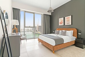 Ein modernes Hotelzimmer mit einem großen Bett, einem Schreibtisch und Blick auf die Stadt.