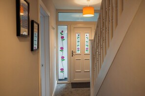 A hallway with a white door, a framed picture on the wall, and a hanging light fixture. - 4BR Humber House for 7|Contractor Stay|Thornaby (Thornaby)