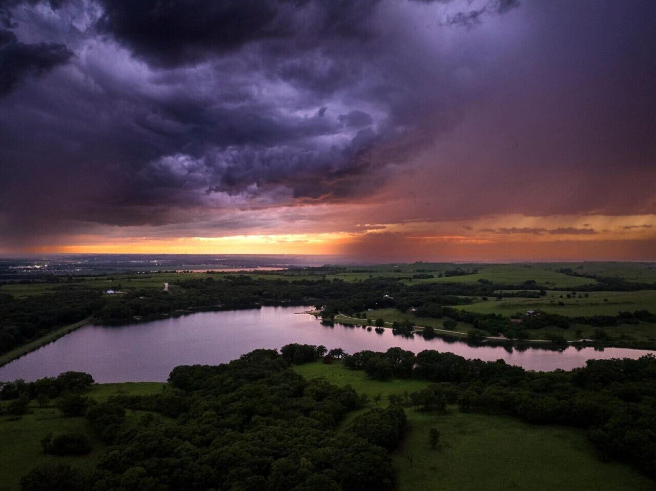 A landscape with a body of water, trees, and a distant horizon.