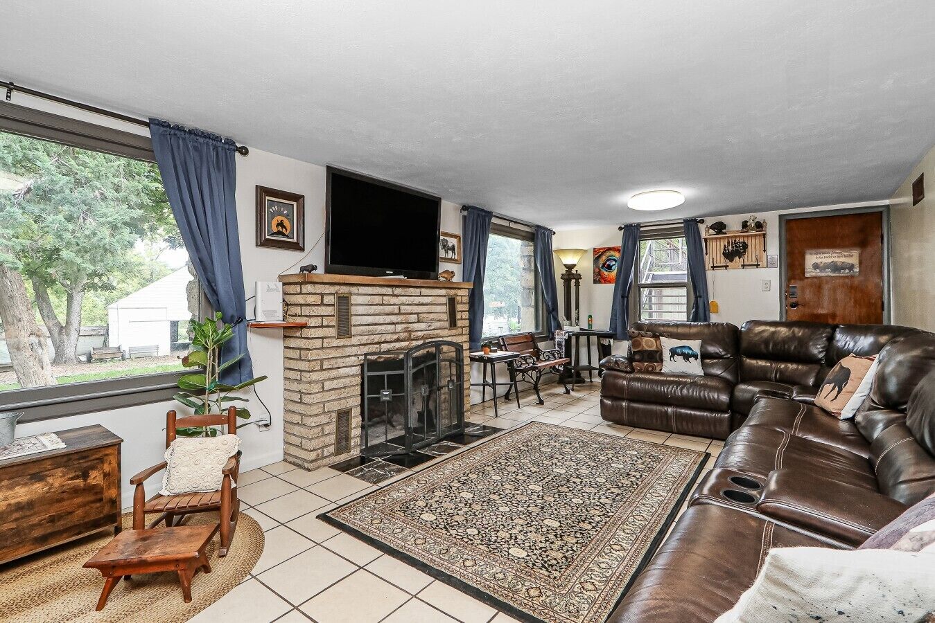 A living room with a fireplace, leather sofa, and a dining area.