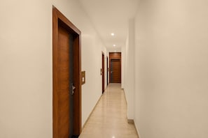 A corridor with wooden doors and a tiled floor, leading to a room with a door marked '205'.