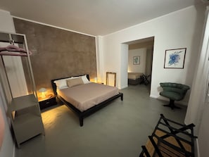 A bedroom with a bed, bedside tables, a chair, and a wardrobe. - An elegant open-concept space in Salerno's harbor area, just a short walk from downtown. (Salerno)