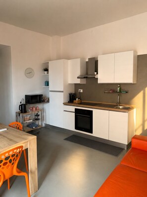A compact kitchen with white cabinets, a microwave, a coffee maker, and a sink. - An elegant open-concept space in Salerno's harbor area, just a short walk from downtown. (Salerno)