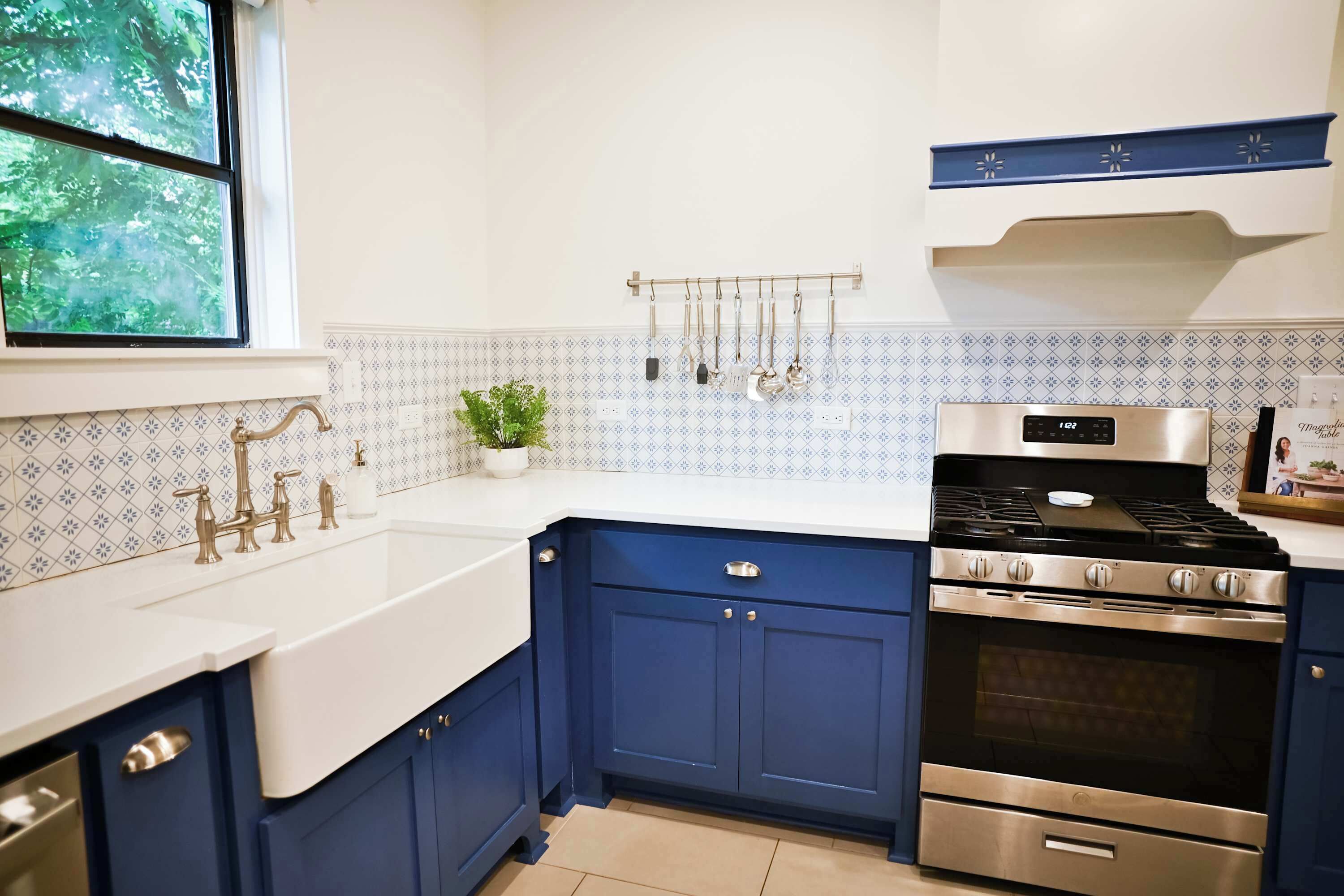 A modern kitchen with a double sink, stainless steel appliances, and blue cabinets.