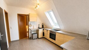 Et moderne køkken med indbygget ovn, vask og vindue.