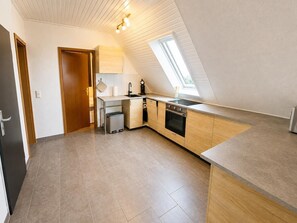 Eine moderne Küche mit eingebautem Backofen, Spüle und Fenster.