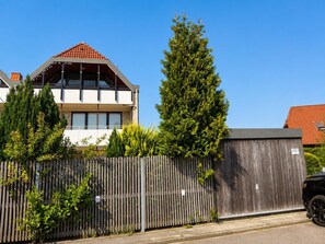 Ein modernes, zweistöckiges Haus mit Satteldach und großen Fenstern.