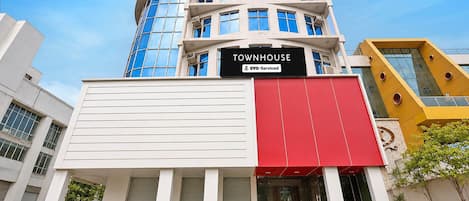 A modern building with a sign reading 'TOWNHOUSE' and 'OYO-Serviced'.