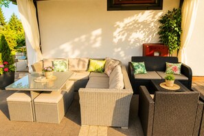 An outdoor seating area with a sofa, chairs, and a glass-top table. - Studio for 2 People, Close to the sea (Kamien Pomorski)