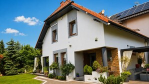 A two-story house with a sloped roof, a covered porch, and a well-maintained lawn. - Studio for 2 People, Close to the sea (Kamien Pomorski)