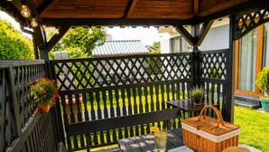 A wooden deck with a bench, a table with a basket and a book, and a potted plant. - Studio for 2 People, Close to the sea (Kamien Pomorski)