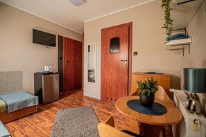 A compact room with a kitchenette, a bed, a dining table, and a small seating area. - Studio for 2 People, Close to the sea (Kamien Pomorski)