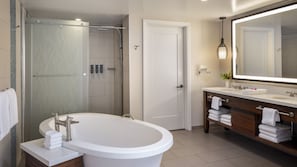 Ein modernes Badezimmer mit einer freistehenden Badewanne, einer begehbaren Dusche und einem Waschtisch mit einem großen Spiegel.