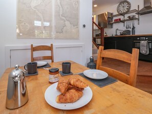 A dining table with a plate of croissants, a coffee pot, and a jar of jam. - Shipwrights (Brixham)