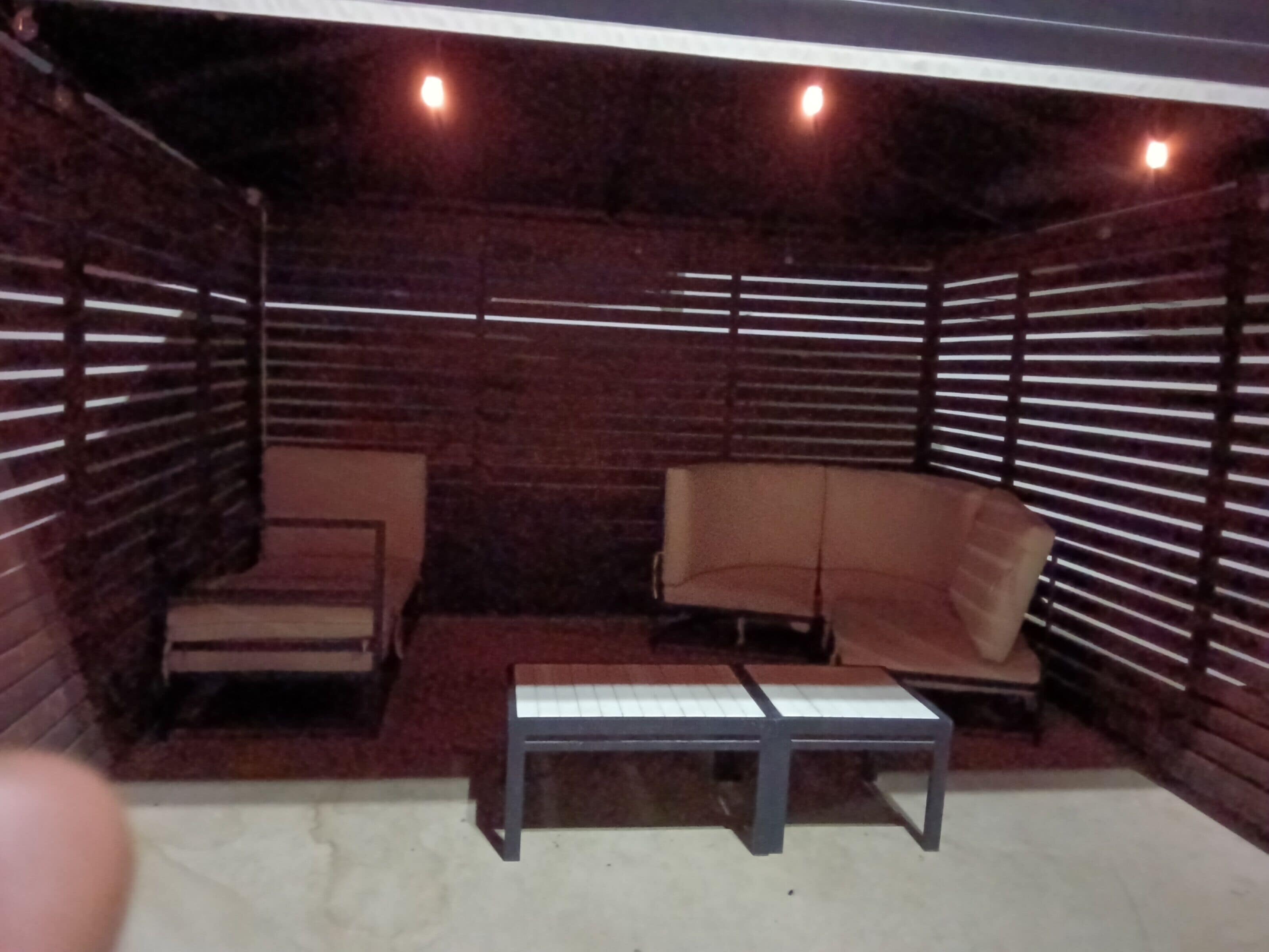 A room with a brick wall, a sofa, a chair, and a small table.