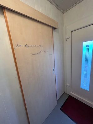 A room with a sliding door, a wooden frame, and a wall-mounted display.