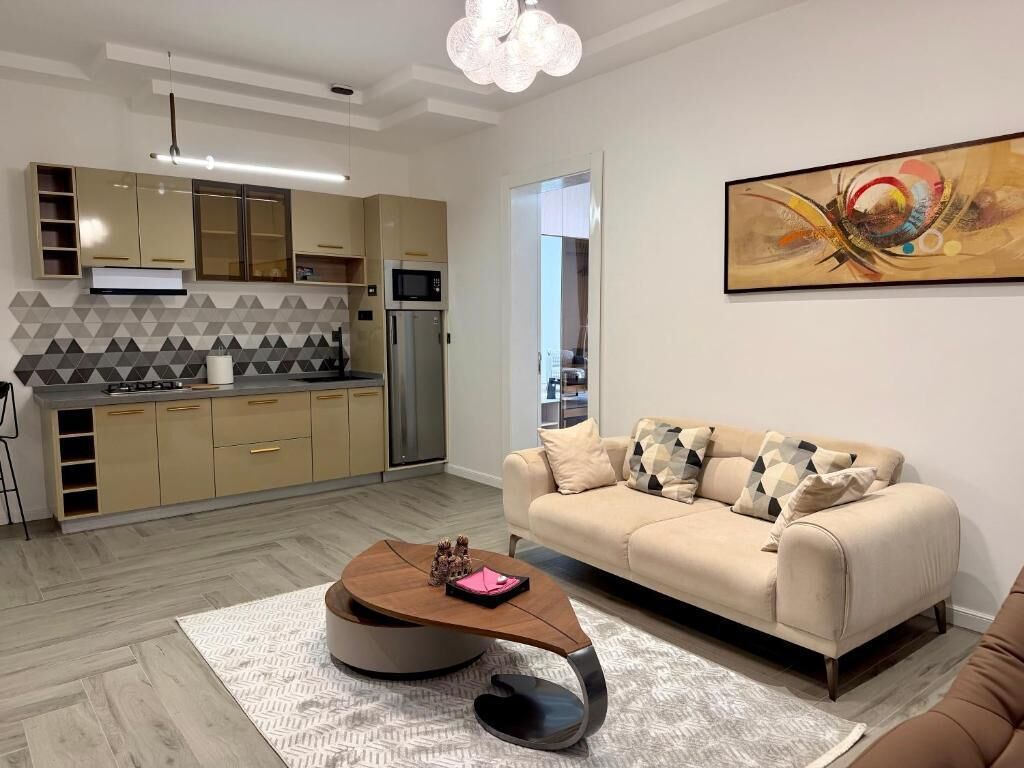 A modern kitchen with a microwave, refrigerator, and a dining area with a round table.