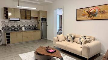 A modern kitchen with a microwave, refrigerator, and a dining area with a round table.