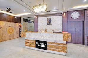 A reception desk with a sign indicating it is serviced by OYO. - Townhouse Rajkot Bus Stand (Rajkot)