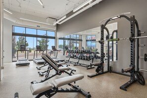 Ein Fitnessstudio mit Laufbändern, Gewichteinrichtungen und Kurzhanteln.